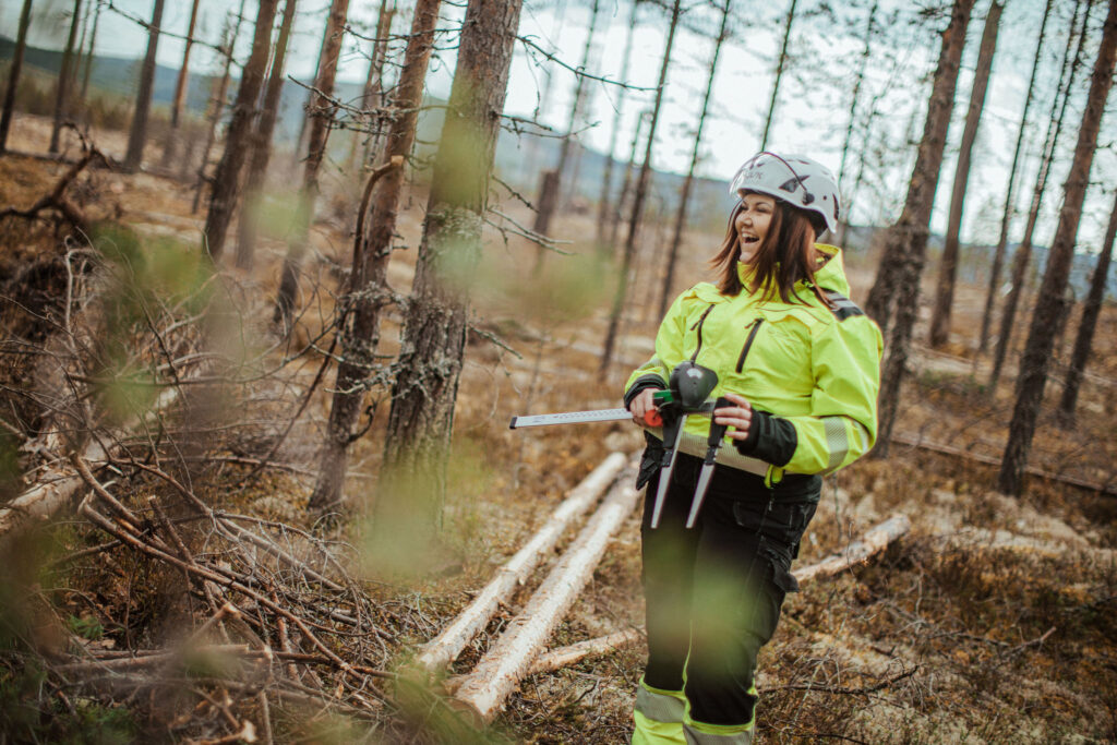 Matilda på Skogsgymnasiet på Älvdalens Utbildningscentrum står med ett skjutmått för att mäta virke i skogen.