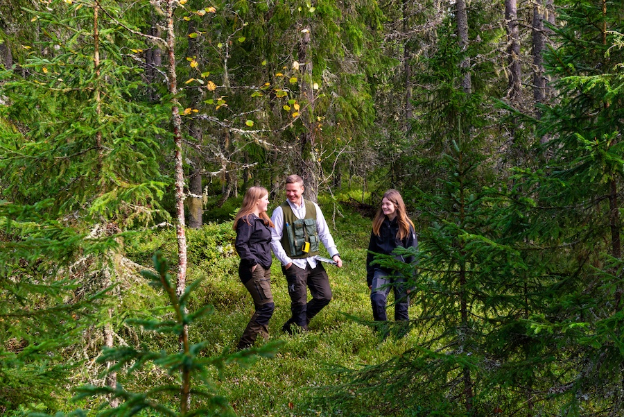 En lärare och två elever på Jaktgymnasiet, går i skogen.